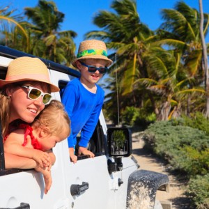 family driving off-road car on tropical beach