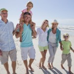 Portrait of smiling multi-generation family walking on sunny beach