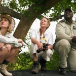 Young woman and mature woman on safari with guide
