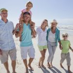 multi-generation family walking on sunny beach